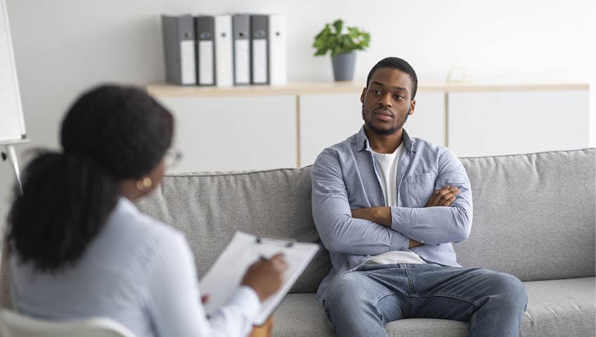 Psychological counselling. Black male patient with depression having session with psychotherapist at office. African American man with PTSD consulting mental health professional at clinic