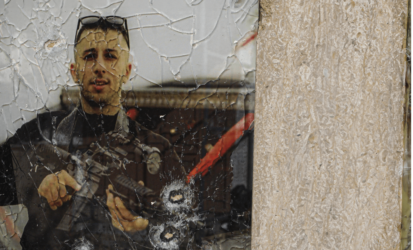 JENIN, PALESTINE - 2023/11/26: A picture of a Palestinian gunman who was killed by Israeli forces a year ago seen on a damaged building wall following an overnight Israeli incursion in the occupied West Bank city of Jenin. Five people were killed by Israeli army fire in Jenin, the Palestinian health ministry said, during an incursion by a large number of armored vehicles into the city, which was recently the scene of the deadliest Israeli raid in the West Bank in almost 20 years. (Photo by Nasser Ishtayeh/SOPA Images/LightRocket via Getty Images)A view of a picture of a Palestinian gunman who was killed by Israeli forces a year ago, hanging damaged following an overnight Israeli incursion in the occupied West Bank city of Jenin on November 26, 2023. Five people were killed by Israeli army fire in Jenin, the Palestinian health ministry said, during an incursion by a large number of armoured vehicles into the city, which was recently the scene of the deadliest Israeli raid in the West Bank in almost 20 years. (