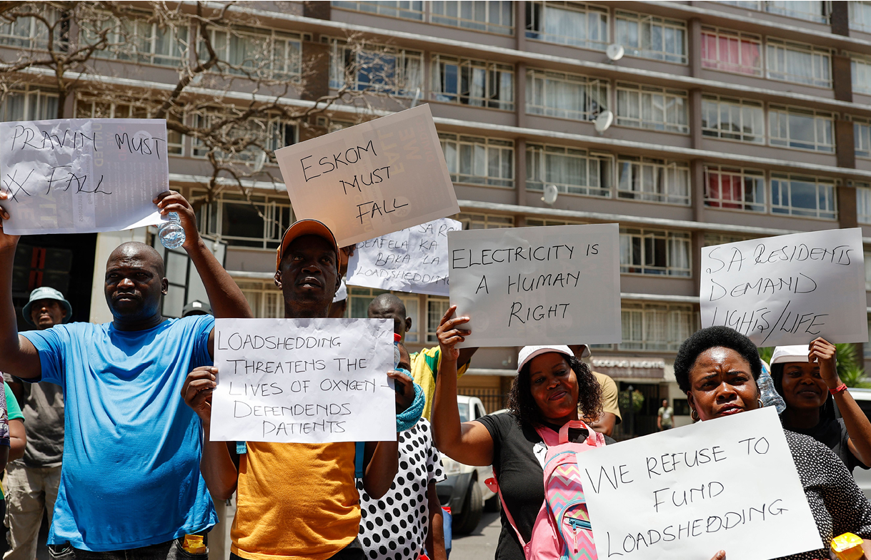 Members of the civil rights movement #NotInMyName hold posters as they march with others in a protest against record blackouts due to troubles at state-owned power utility Eskom and a raise in prices by 18.65 percent in Pretoria on January 20, 2023. (Photo by Phill Magakoe / AFP) (Photo by PHILL MAGAKOE/AFP via Getty Images)