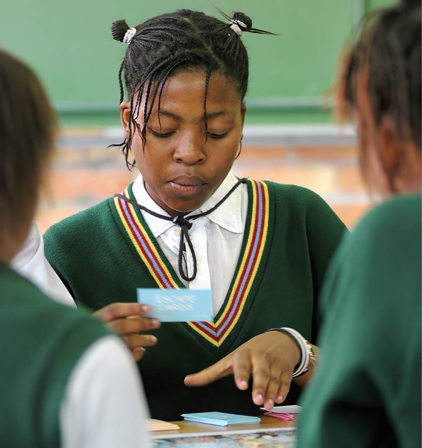JOHANNESBURG, SOUTH AFRICA - NOVEMBER 26: Schoolgirls from Athlone High School play a board game entitled “The Magical Aids Journey" on November 26, 2004 in Johannesburg, South Africa. The game, created by a South African social worker, helps children, especially those who have an HIV or AIDS infected loved one, process their feelings about the disease. (Photo by Naashon Zalk/Getty Images)