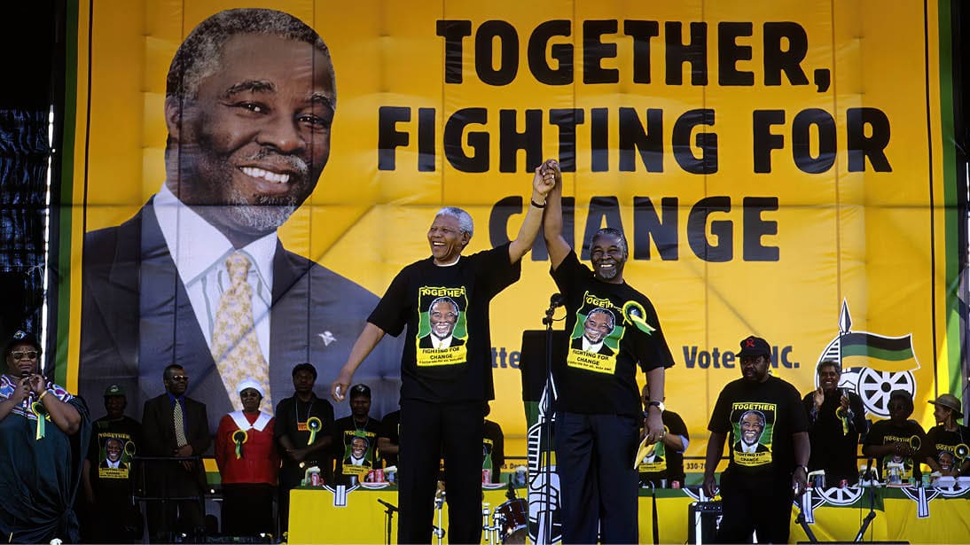 SOWETO, SOUTH AFRICA - FEBRUARY 28: President Nelson Mandela holds the hand of deputy president Thabo Mbeki during the start of the election campaign on February 28, 1999 in Soweto, South Africa. About 100.000 people attended the rally, and it was President Mandela?s last election campaign. Mandela retired after one term in 1999 and gave leadership to the current president Mr. Thabo Mbeki. (Photo by Per-Anders Pettersson/Getty Images)
