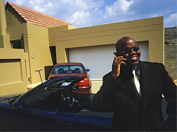 JOHANNESBURG, SOUTH AFRICA - MARCH 22: Oscar Dube, a young successful black man speaks on his mobile phone on March 22, 2002 in Johannesburg, South Africa. Oscar used to work for Ericsson, the Swedish mobile phone and equipment maker, but now has his own company in the telecom business. A growing number of people belong to the new black elite in the country. Well educated and connected, they have risen from the poverty in the townships to a very different lifestyle, since the fall of Apartheid and the start of democracy in the country in 1994. (Photo by Per-Anders Pettersson/Getty Images)