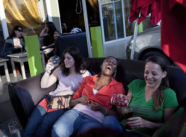 JOHANNESBURG, SOUTH AFRICA - MAY 16: Lulekwa Sbukwana, (c) age 30, who works in the financial business enjoys a lazy Sunday afternoon with her white friends in a restaurant on May 16, 2010, in Melville, Johannesburg, South Africa. Lulekwa is part of the new young generation of black South African's who has obtained a better education and opportunities than their parents. She makes about US$ 1200 per month and lives in her own apartment. The country has seen a big increase in a black middle class since the end of Apartheid and democracy in 1994.  (Photo by Per-Anders Pettersson/Getty Images)