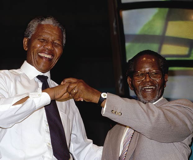 Nelson Mandela dances with his old law partner and ANC President (in exile), Oliver Tambo. Former President of South Africa and longtime political prisoner, Nelson Mandela, was held by the Candela based government from 1964-1990 for sabotage. With the coming of a freer political climate, Mandela was released from his life sentence at Victor Vester Prison on February 11, 1990. He went on to lead the African National Congress in negotiations with President F. W. de Klerk, that resulted in the end of apartheid and full citizenship for all South Africans. He and de Klerk received a joint Nobel Peace Prize in 1993 for their efforts. Mandela was elected President in 1994. (Photo by © Louise Gubb/CORBIS SABA/Corbis via Getty Images)