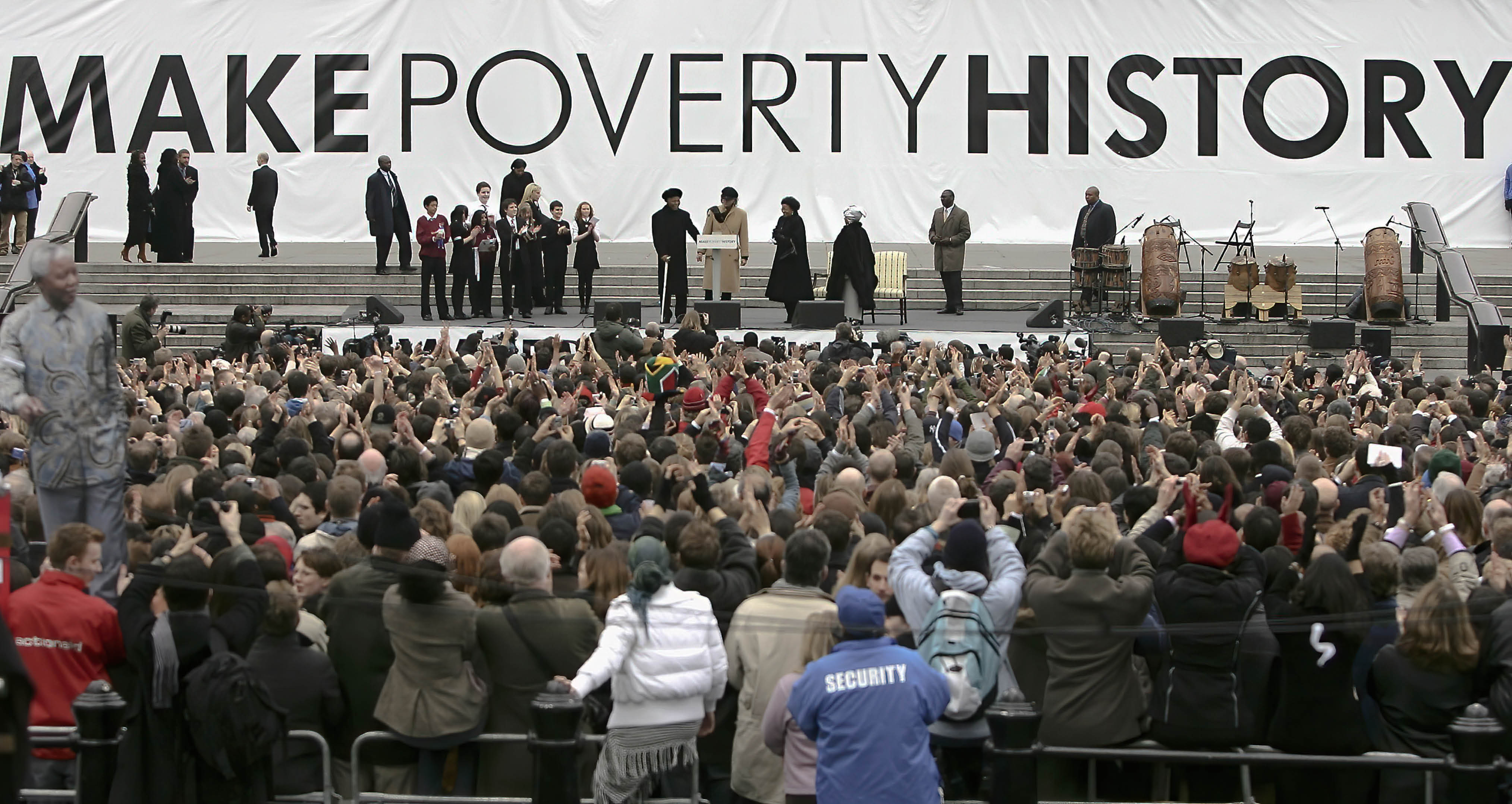 LONDON - FEBRUARY 3: Nelson Mandela and Sir Bob Geldof are applauded by the crowd before making a speech endorsing the 'Make Poverty History' campaign on January 3, 2005 in London, England.  The former South Africa president will meet with Finance Ministers from the G7 countries on Friday February 4 discussing world debt relief and encouraged the crowds at the rally to join the campaign against poverty.  (Photo by Bruno Vincent/Getty Images)