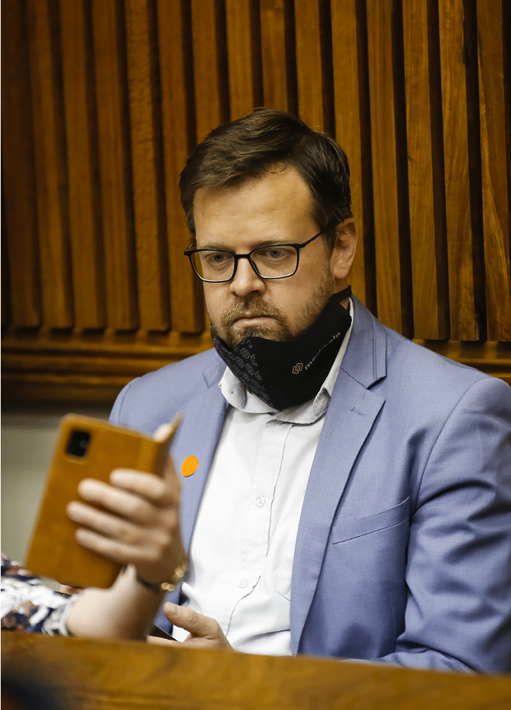 Afriforum's Deputy CEO Ernst Roets looks at a mobile phone while Economic Freedom Fighters (EFF) leader Julius Malema (not visible) appears at the Randburg Magistrate Court, near Johannesburg, on October 13, 2020. - Julius Malema is accused of assaulting a South African Police Services (SAPS) colonel during the funeral service of the late struggle icon Winnie Madikizela-Mandela in April 2018. (Photo by Phill Magakoe / AFP) (Photo by PHILL MAGAKOE/AFP via Getty Images)