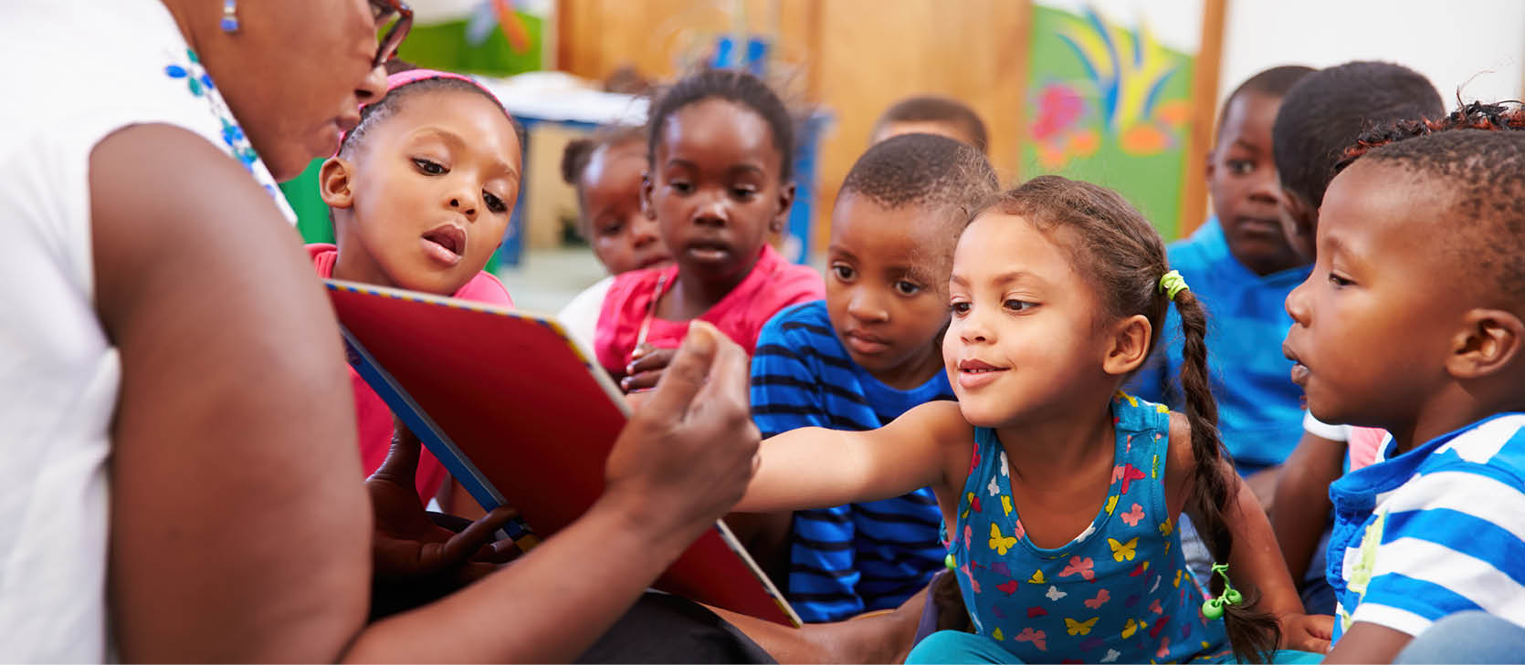 Teacher reading a book with a class of preschool children