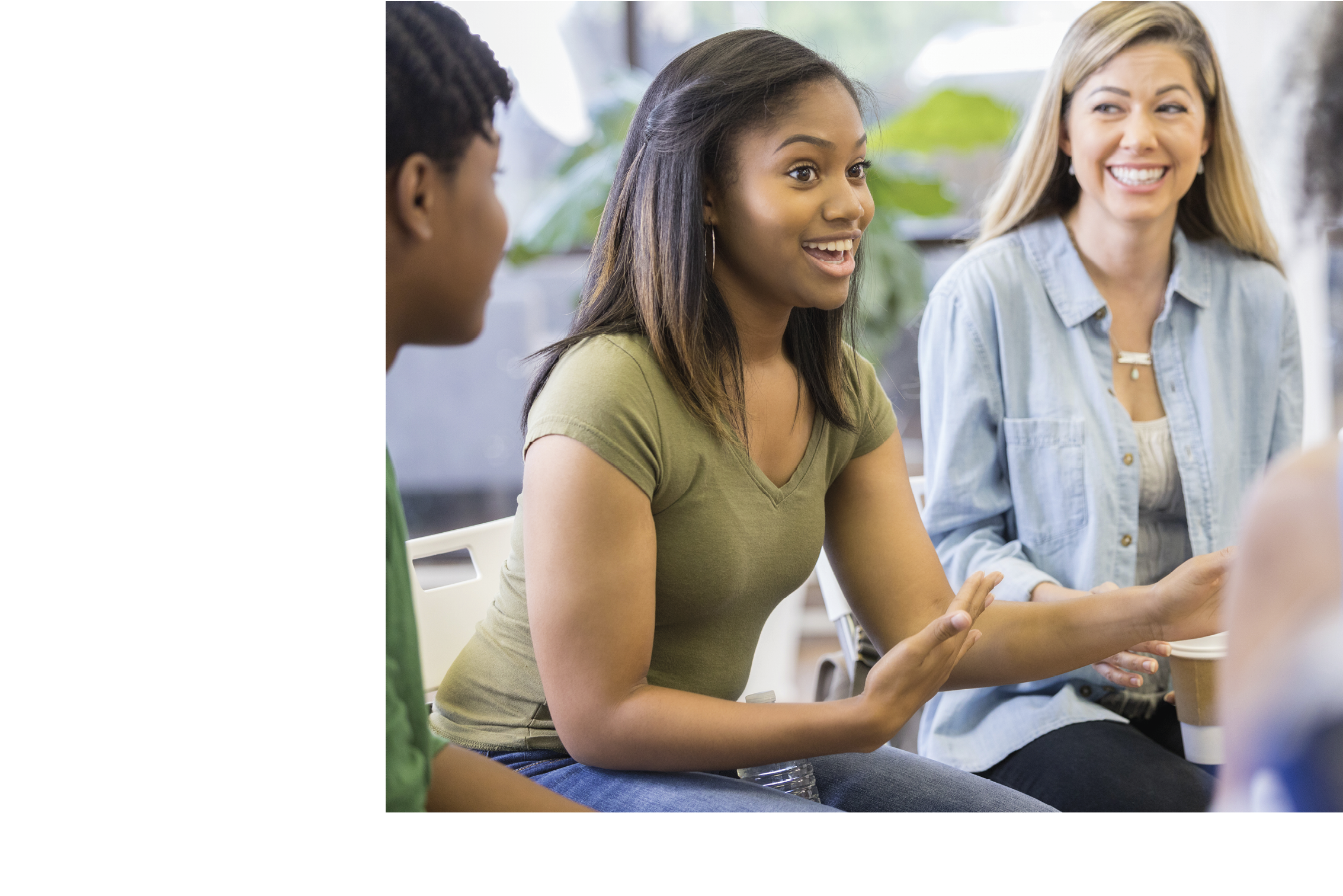Teenage girl gestures as she discusses something during a support group or group therapy session.