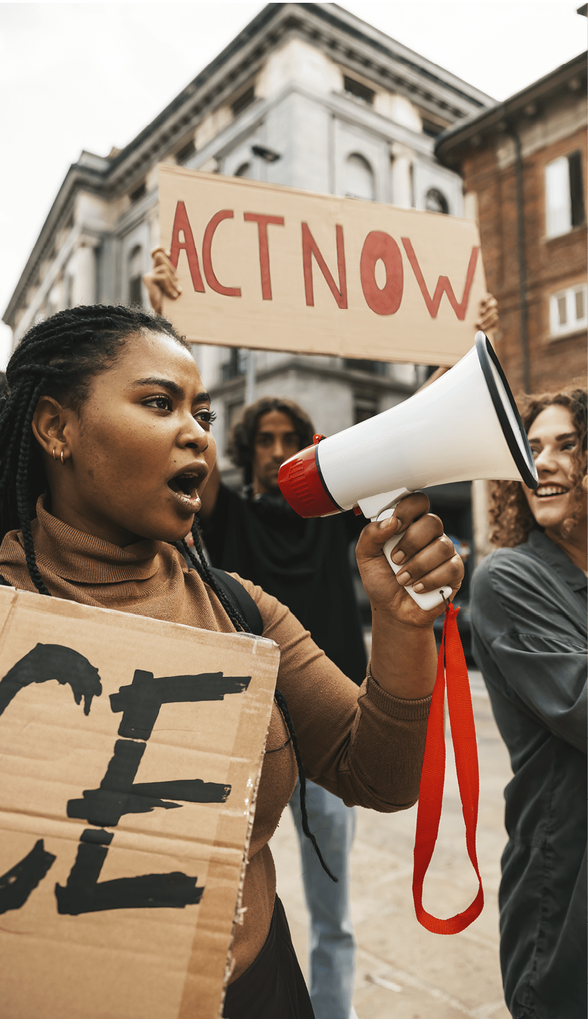 People united against racism. Anti-Racism protest. Protestors holding hand-made signs on cardboards and marching together in the city streets in downtown.