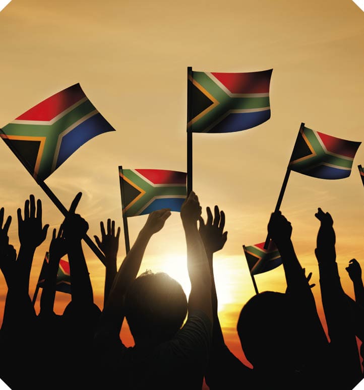 Group of People Waving South African Flags in Back Lit